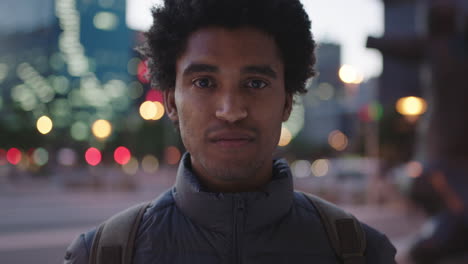 portrait of charming young mixed race man looking pensive at camera serious male in urban evening background