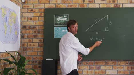 portrait of caucasian male teacher teaching mathematics in the classroom at school