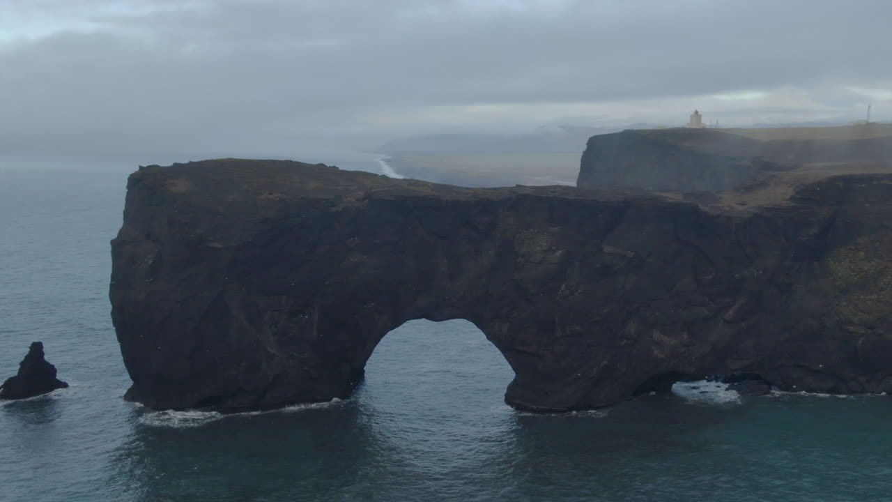 fotografía aérea de niebla impresionante a principios del invierno en la playa de arena negra de los apóstoles fuego y hielo océano junto al faro de dyhrolaey y la cueva reynisfjara islandia