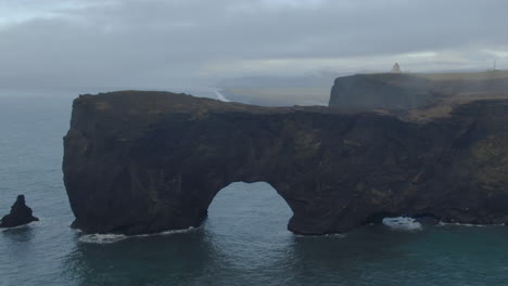 aerial still shot stunning fog early winter at black sand beach apostles fire and ice ocean next to dyhrolaey lighthouse and cave reynisfjara iceland