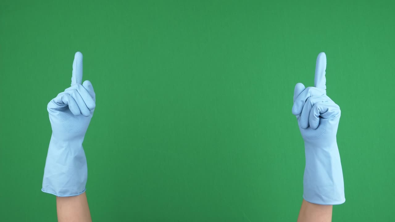 Female hands with blue protective rubber gloves rise up and fingers point upwards over empty chroma key green screen background. Hand gesture. 4 k video