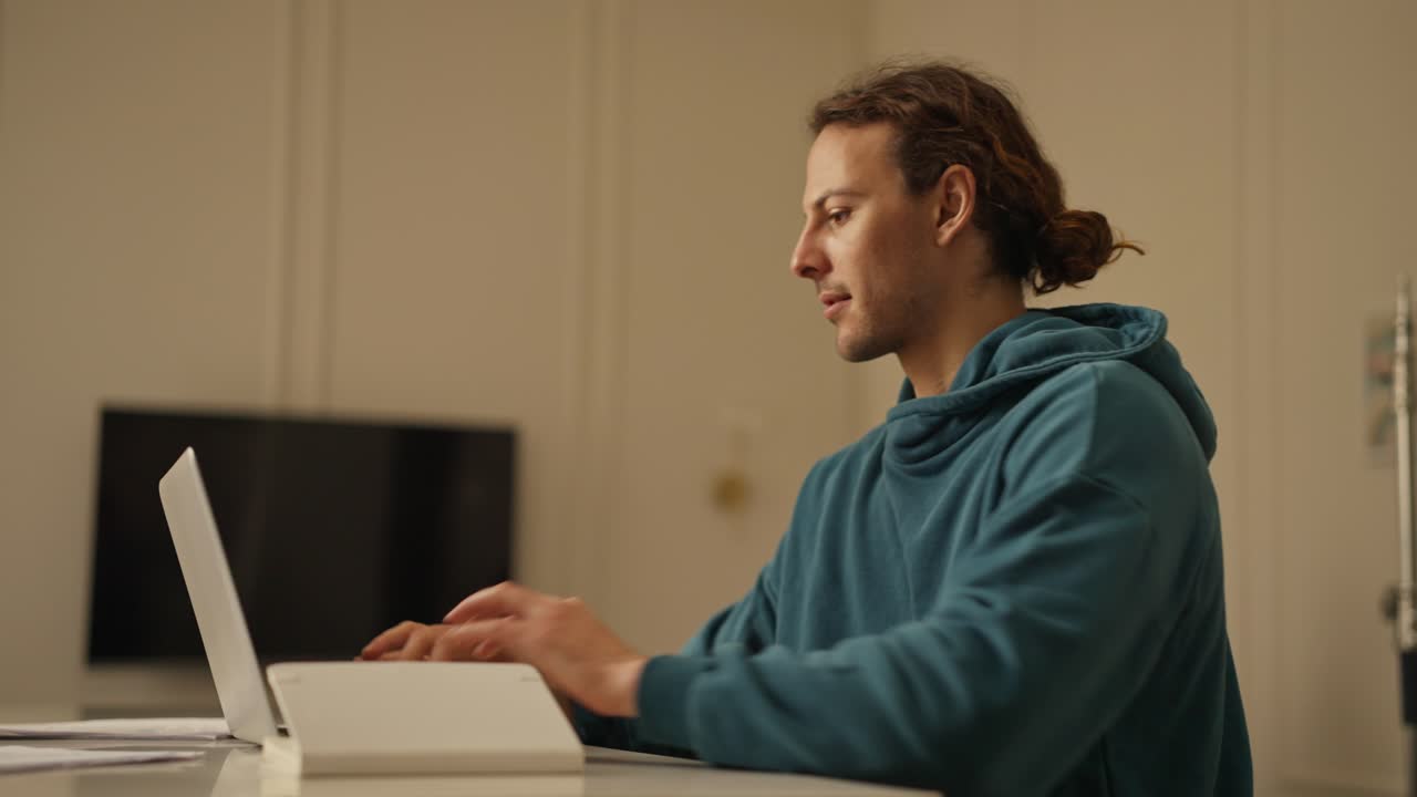 Man Working from Home with Laptop and Notebook