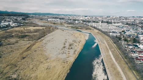 aerial view of tama river with city buildings at daytime in tokyo, japan