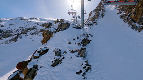 a wide shot from a chairlift spectacularly passing over a ridge in les deux alpes in the french alps