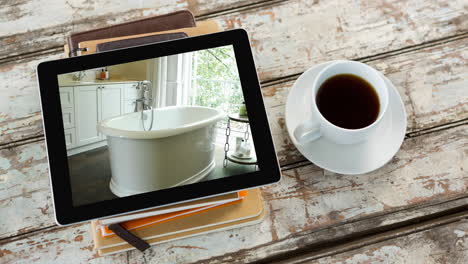 digital tablet with modern bathroom interiors displayed on screen on wooden surface