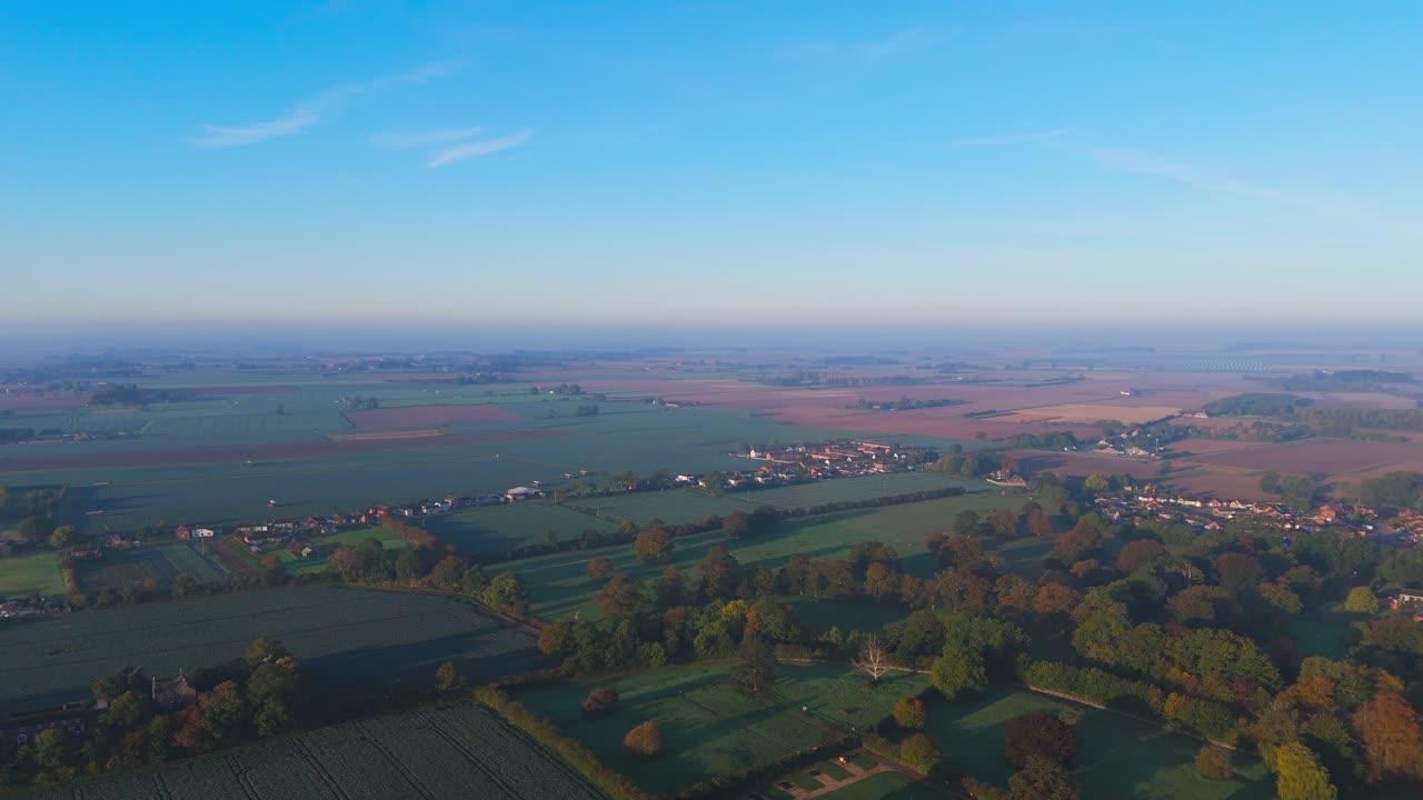 Misty autumn morning with farmlands and countryside views, wide vistas across open fields with crops set for overwintering. cold days in a rural village setting