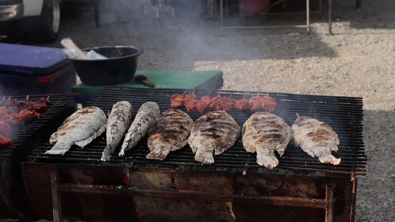 시장에서 나무 석탄 위에 갈아먹는 물고기.