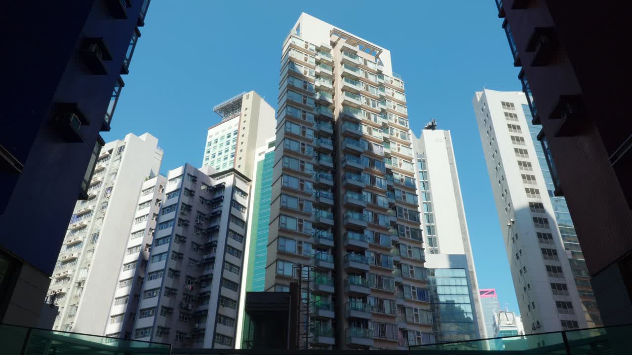 Veduta panoramica di condomini e grattacieli nel centro di Hong Kong, Cina, in una giornata di sole, che mostra una densa vita urbana e un'architettura moderna.