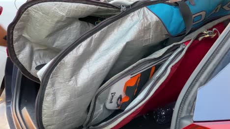 man surfer keeps surfboard in car trunk at beach on sunny day after enjoying outdoor activity and water sports lifestyle surfing in summer vacation