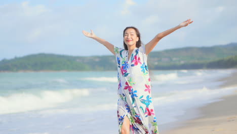 young happy asian woman smiles and rejoices on beach