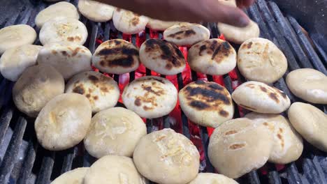 a street vendor in kolkata can be seen in this video tossing litti over charcoal in an iron grill to cook it evenly so that it can be served with roasted mashed eggplant or baingan bharta and a green