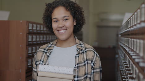 young woman in library holding books