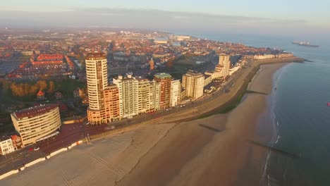 aerial: the boulevard, beach and city of vlissingen during sunset