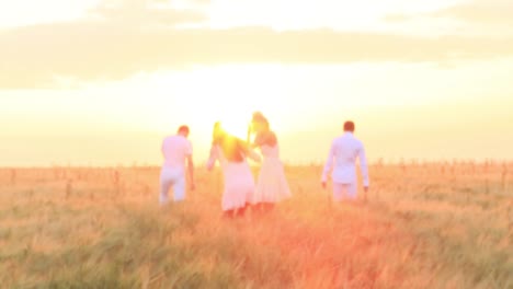 friends enjoying sunset in wheat field