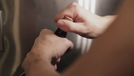 opening a bottle of wine by pulling the cork all the way out with a hand - close up shot