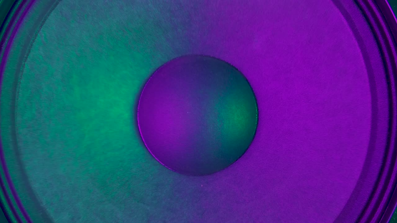 tocando membranas de altavoces iluminadas por coloridas luces de neón de discoteca. poderosos altavoces modernos vibran rebotando al ritmo de la música electrónica. cerca. movimiento lento