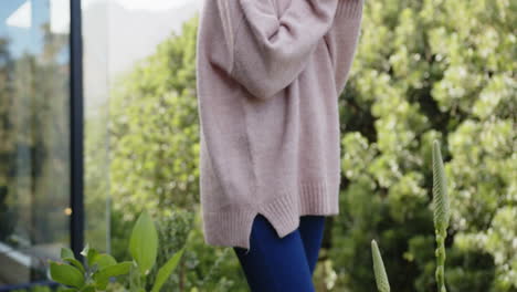 holding cup, woman enjoying outdoor relaxation in cozy sweater