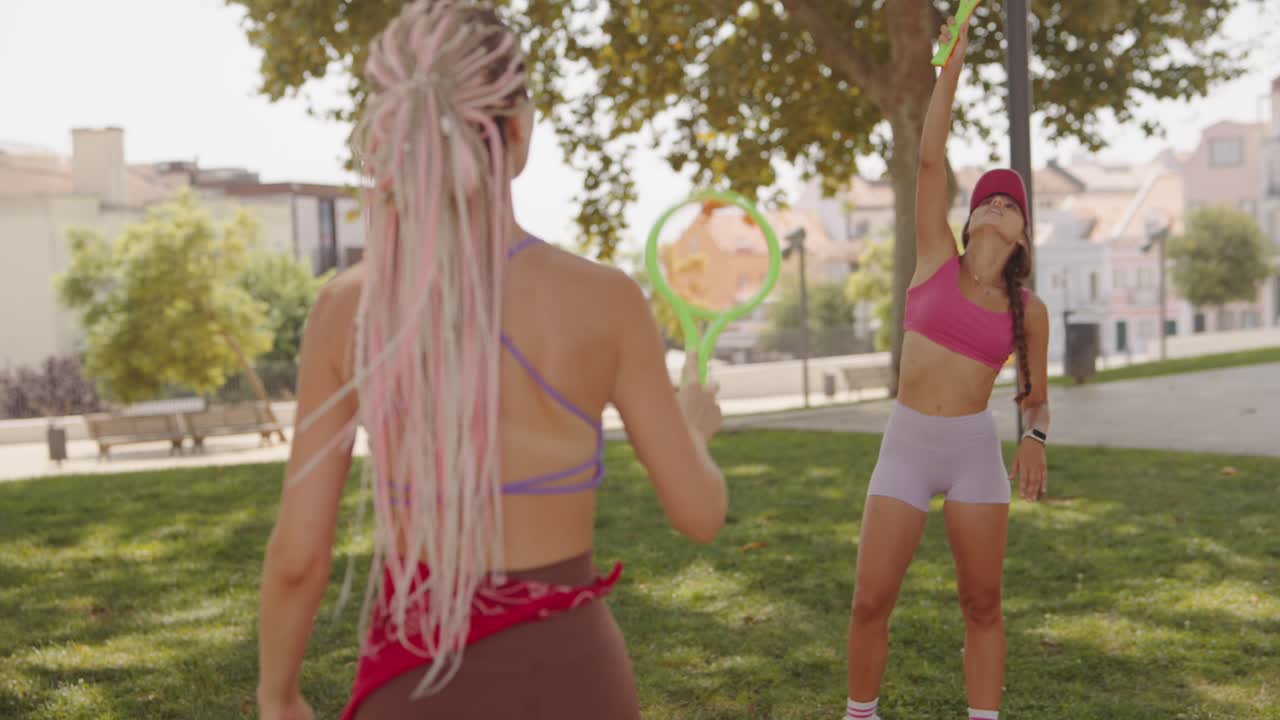 Women playing racket in park