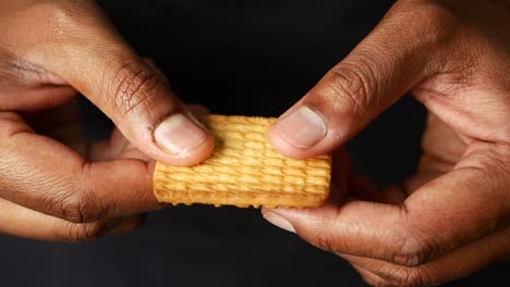 las manos rompiendo una galleta crujiente