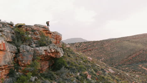 young caucasian man stands on a cliff edge, outdoor with copy space