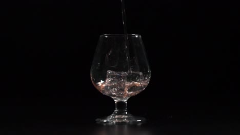 filling glass with drink on the rocks slow motion 4k