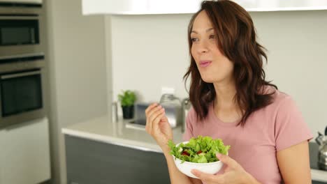 pretty woman eating a bowl of healthy salad