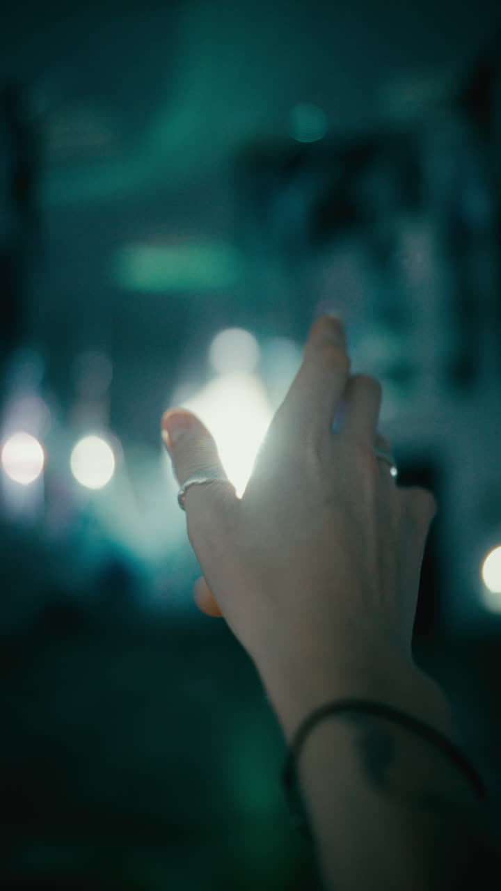 Close Up of Female Hand Reaching toward Bright Light in Darkness