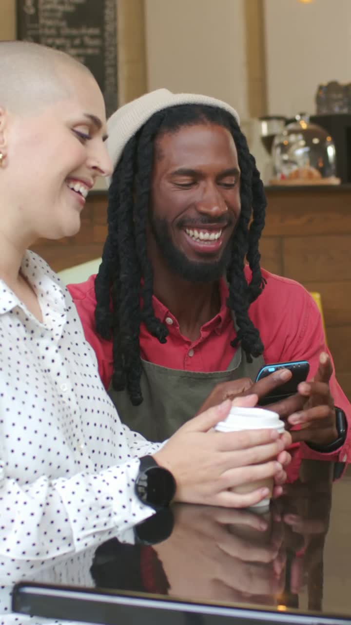 Vertical video: Tapping barista apron showing phone in cafe woman with cup walking back to work