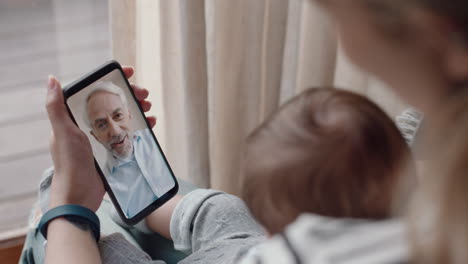 Junge-Mutter-Und-Baby-Chatten-Per-Video-Mit-Dem-Großvater-über-Das-Smartphone-Und-Winken-Dem-Neugeborenen-Kind-Zu,-Das-Die-Familiäre-Verbindung-Genießt