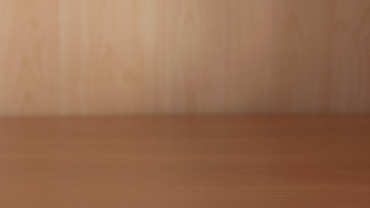 la mano de un hombre pone una bolsa de plástico llena de manzanas rojas frescas sobre una mesa de madera y luego la recoge