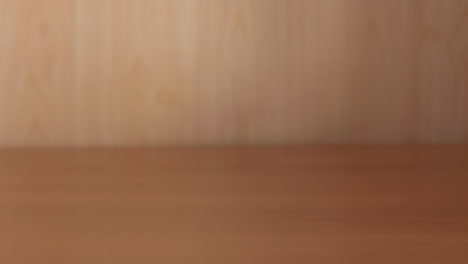la mano de un hombre pone una bolsa de plástico llena de manzanas rojas frescas sobre una mesa de madera y luego la recoge