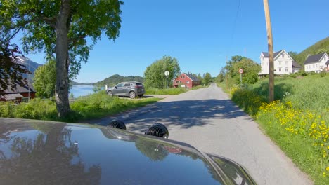 Conduciendo-En-El-Norte-De-Noruega,-Vista-Del-Capó-A-Través-Del-Pueblo-Noruego-Con-Caminos-Estrechos,-Cámara-Lenta