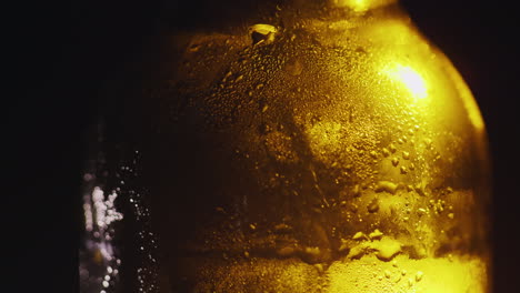 primer plano de una botella de vidrio con gotas de concepto de bebida fría de agua condensada sobre un fondo negro 4k