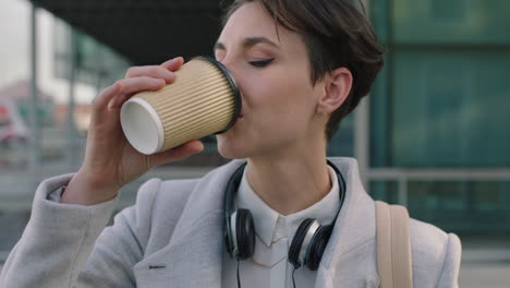 close up portrait of young business woman commuter drinking coffee in city