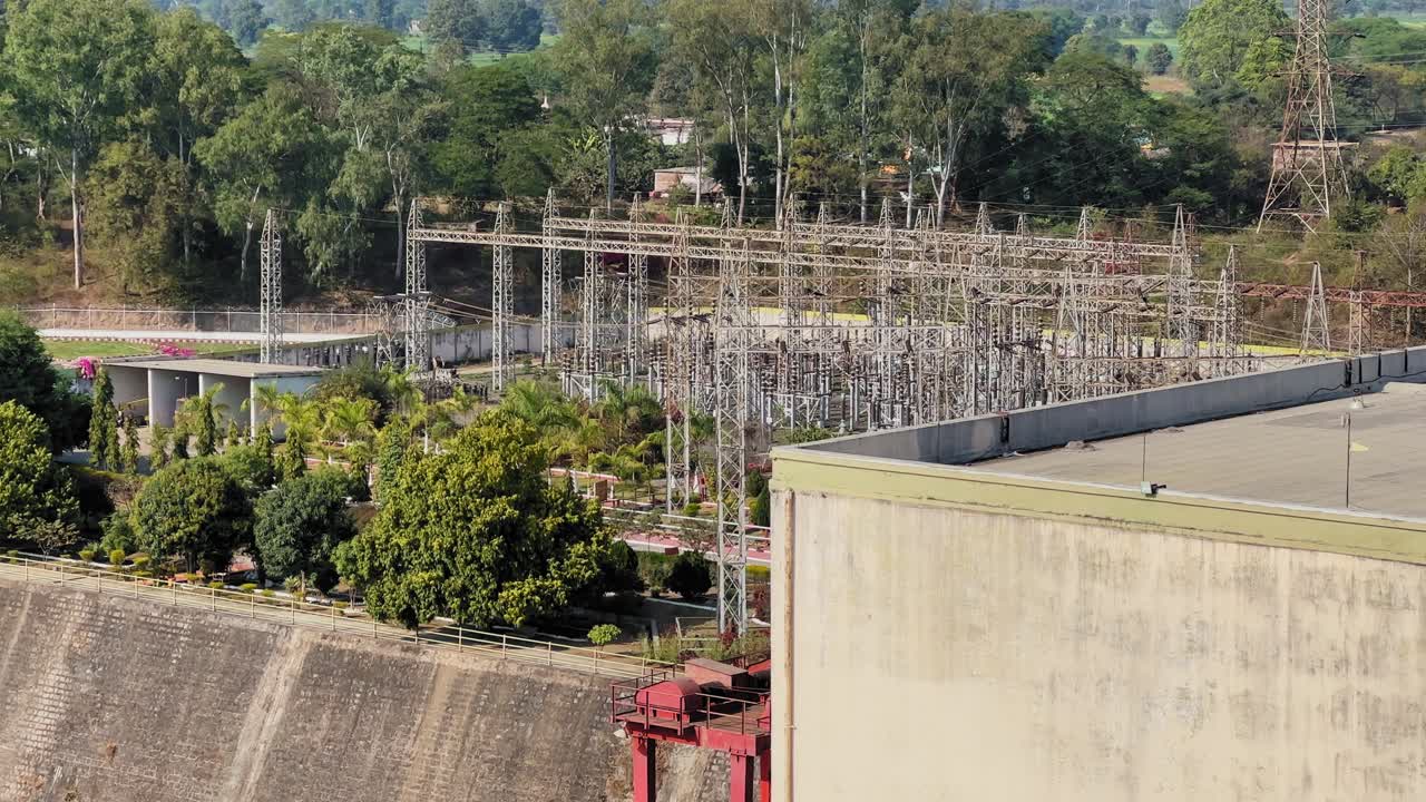 Statische Aufnahme zeigt das Stromnetz, das die Stromerzeugung am Bargi-Damm in Jabalpur unterstützt, mit Hochspannungsmasten, Umspannwerken, Grünflächen und Beton-Infrastruktur