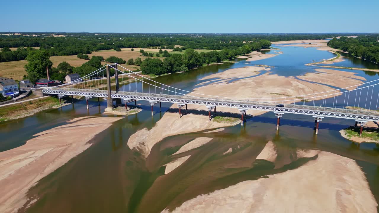 Varades suspension bridge over Loire River, low water level and large sandbanks, France. Aerial drone lateral view
