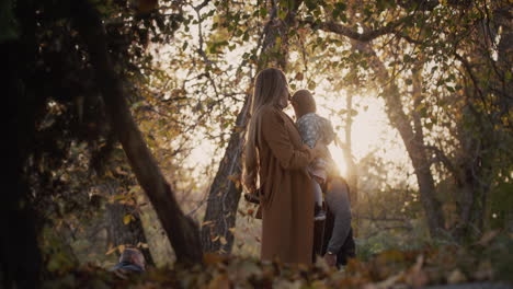 Family-have-fun-in-autumn-park,-throw-up-leaves,-have-a-good-time-together