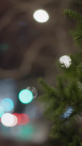 primer plano de una rama de pino sacudiendo suavemente por la noche, con hermosos efectos de luz bokeh en el fondo