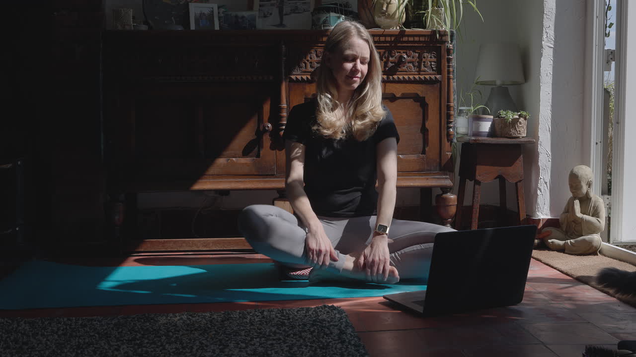 mujer practicando yoga en casa