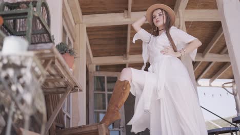 bohemian woman in a white dress on a wooden porch