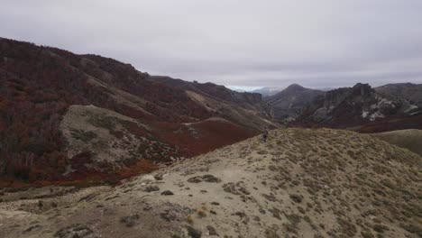 seguimiento por drones de una persona corriendo por el borde de una montaña para llegar al mirador desde donde se tiene la mejor vista de las montañas en otoño