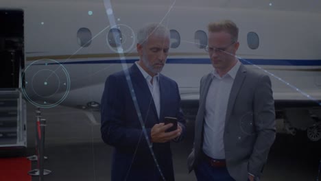 Network-of-connections-against-two-caucasian-businessmen-discussing-together-at-the-airport