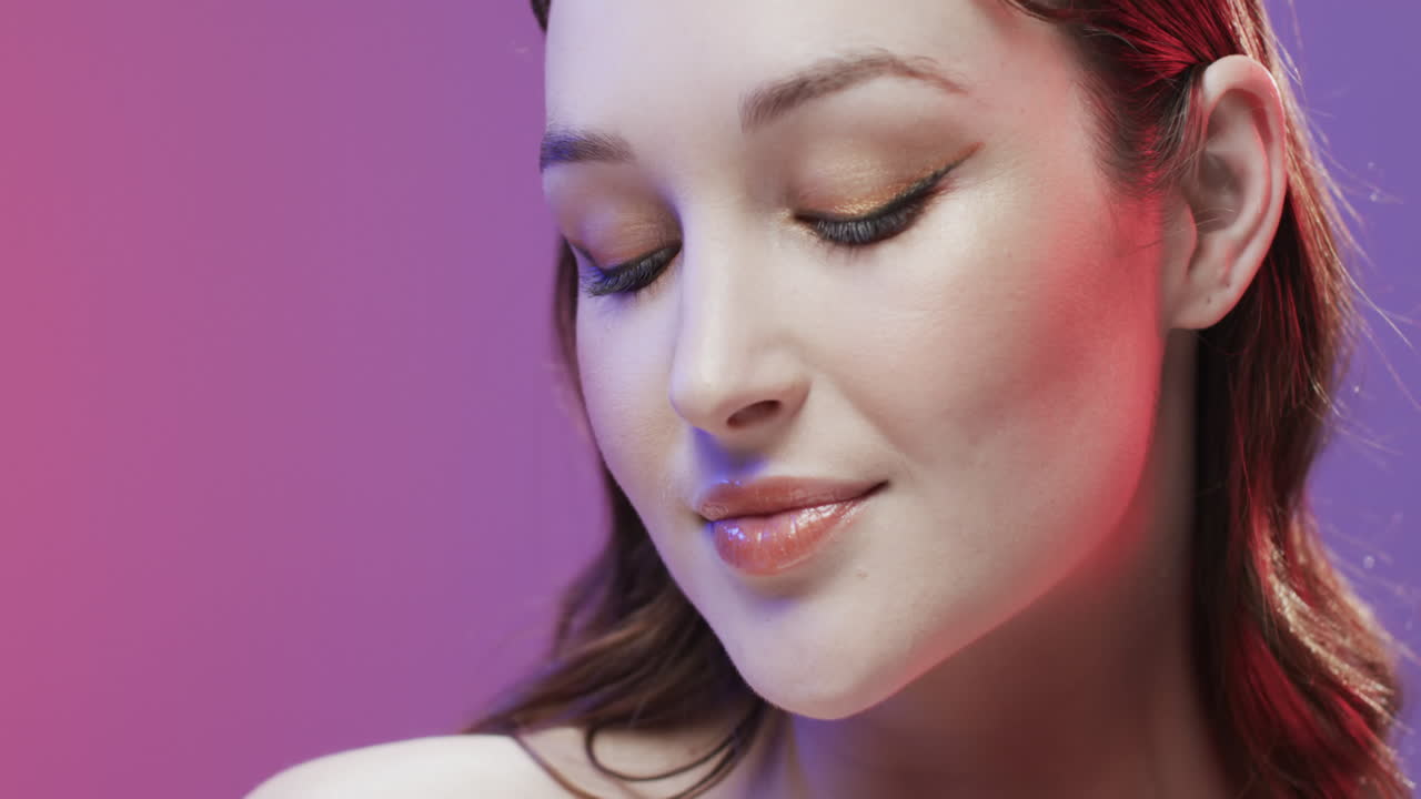 Caucasian woman with brown hair and make up smiling, copy space, slow motion