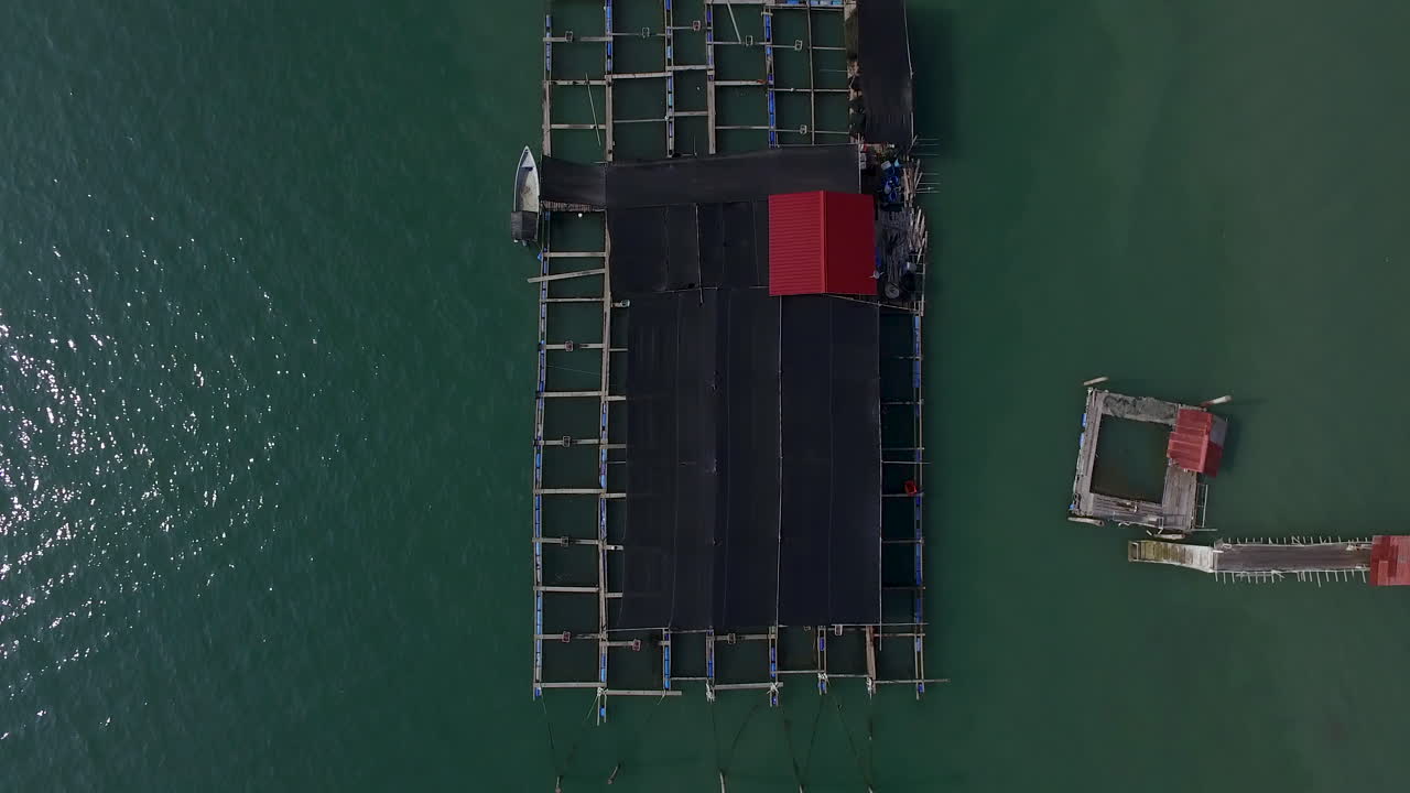 primitivo sistema de jaulas de piscifactoría en la isla tropical de malasia