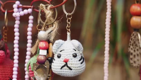 close-up of a crocheted cat keychain and other hanging crafts