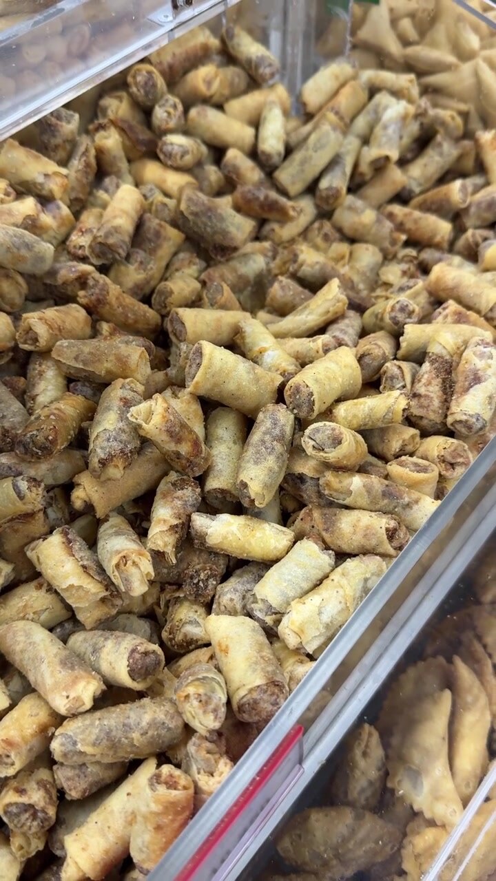 Pile of Golden Fried Mini Spring Rolls in a Display Bin