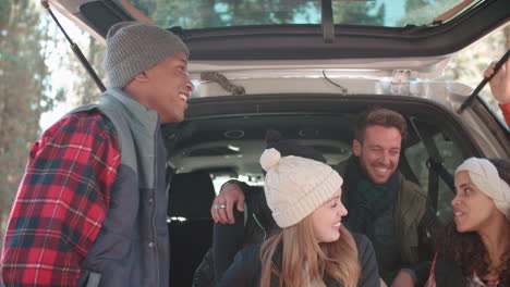 Friends-talking-at-the-open-back-of-a-car,-close-up