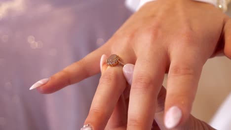 la novia ajusta el anillo de compromiso en su dedo