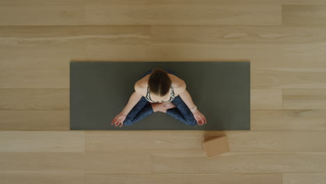 Oben-Gesehene-Yoga-Frau-Praktiziert-Lotus-Pose-Im-Trainingsstudio-Und-Genießt-Einen-Gesunden-Lebensstil,-Meditationsübungstraining-Auf-Einer-Trainingsmatte