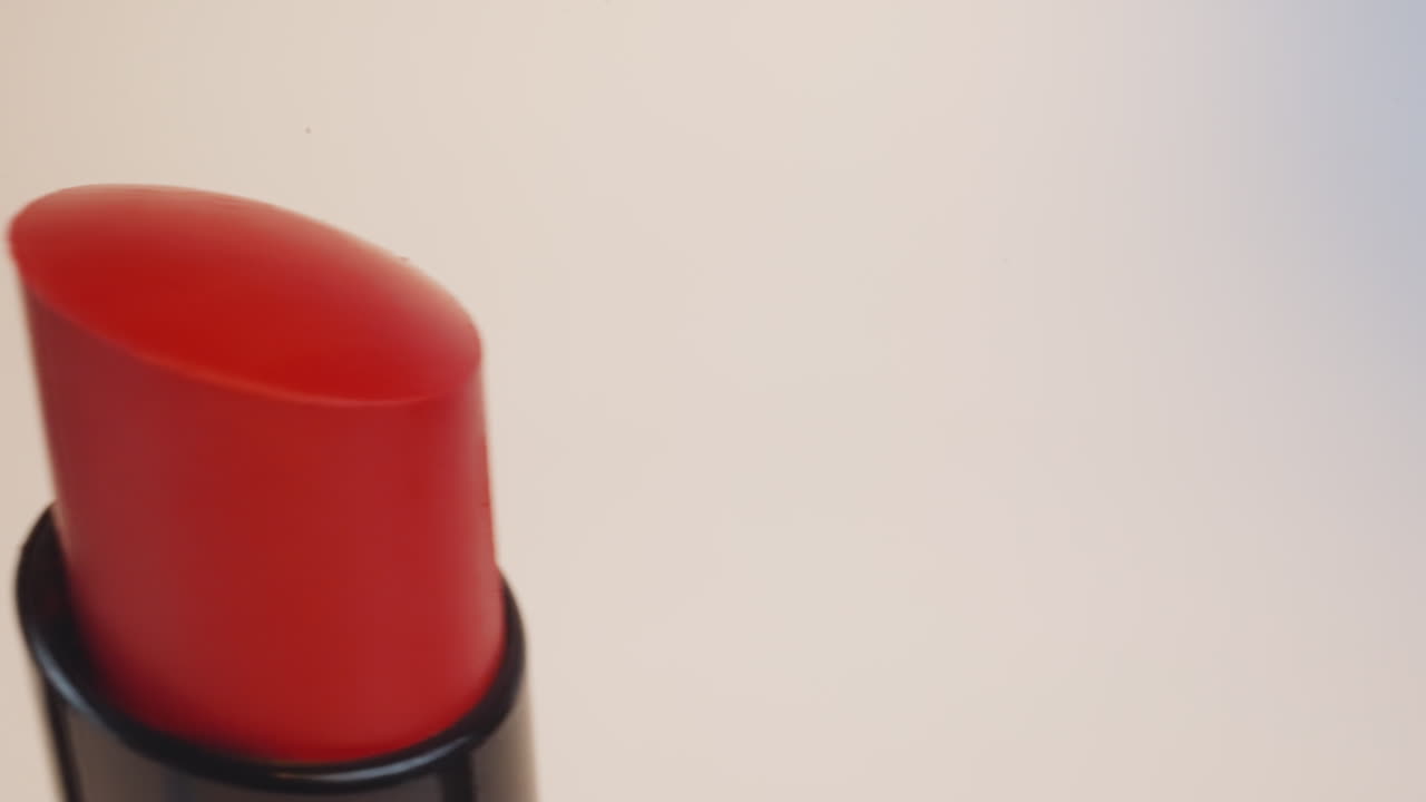 lápices labiales rojos brillantes para maquillaje de noche sobre fondo beige